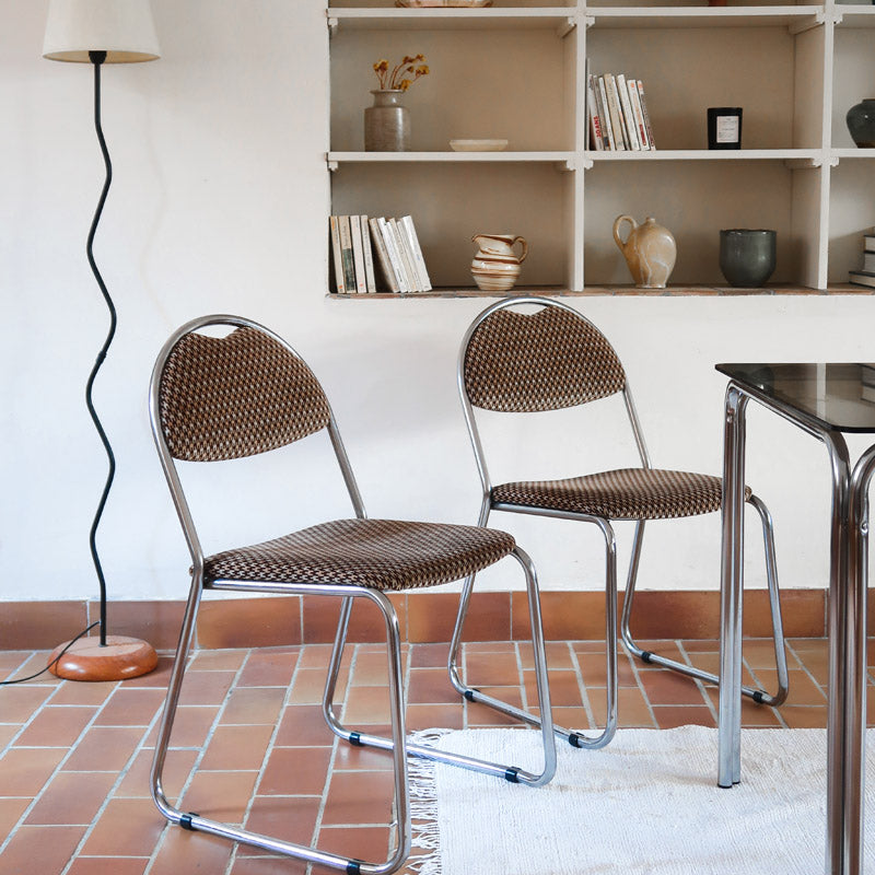 Paire de chaises vintage en chrome tubulaire avec assise et dossier en tissu à motif géométrique.
