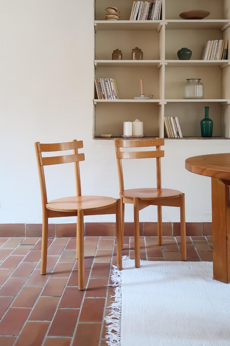 Paire de chaises vintage en hêtre massif, assise ronde et dossier à deux barreaux, style bistrot scandinave, présentées seules et en mise en situation.