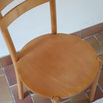 Paire de chaises vintage en hêtre massif, assise ronde et dossier à deux barreaux, style bistrot scandinave, présentées seules et en mise en situation.