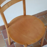 Paire de chaises vintage en hêtre massif, assise ronde et dossier à deux barreaux, style bistrot scandinave, présentées seules et en mise en situation.