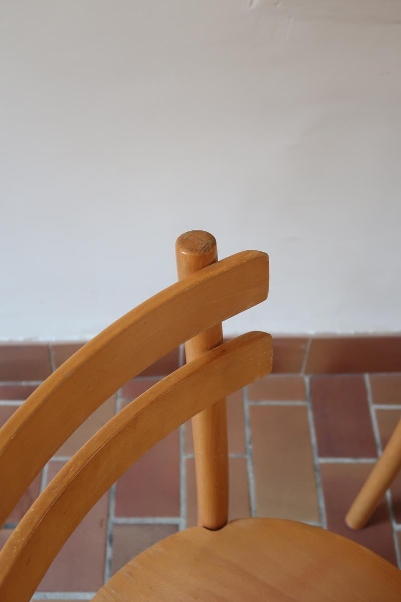 Paire de chaises vintage en hêtre massif, assise ronde et dossier à deux barreaux, style bistrot scandinave, présentées seules et en mise en situation.