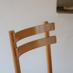 Paire de chaises vintage en hêtre massif, assise ronde et dossier à deux barreaux, style bistrot scandinave, présentées seules et en mise en situation.