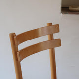 Paire de chaises vintage en hêtre massif, assise ronde et dossier à deux barreaux, style bistrot scandinave, présentées seules et en mise en situation.