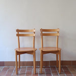 Paire de chaises vintage en hêtre massif, assise ronde et dossier à deux barreaux, style bistrot scandinave, présentées seules et en mise en situation.