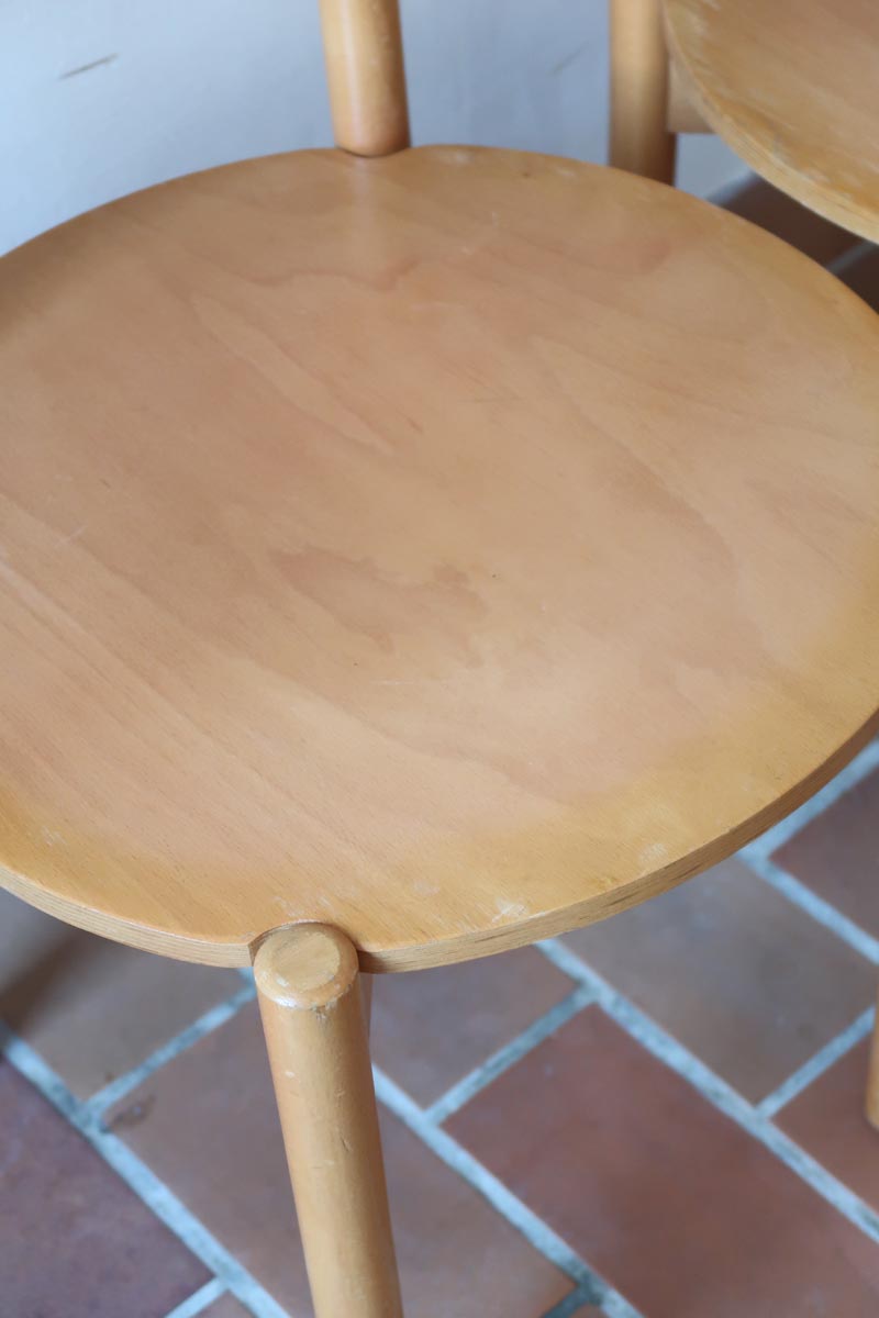 Paire de chaises vintage en hêtre massif, assise ronde et dossier à deux barreaux, style bistrot scandinave, présentées seules et en mise en situation.