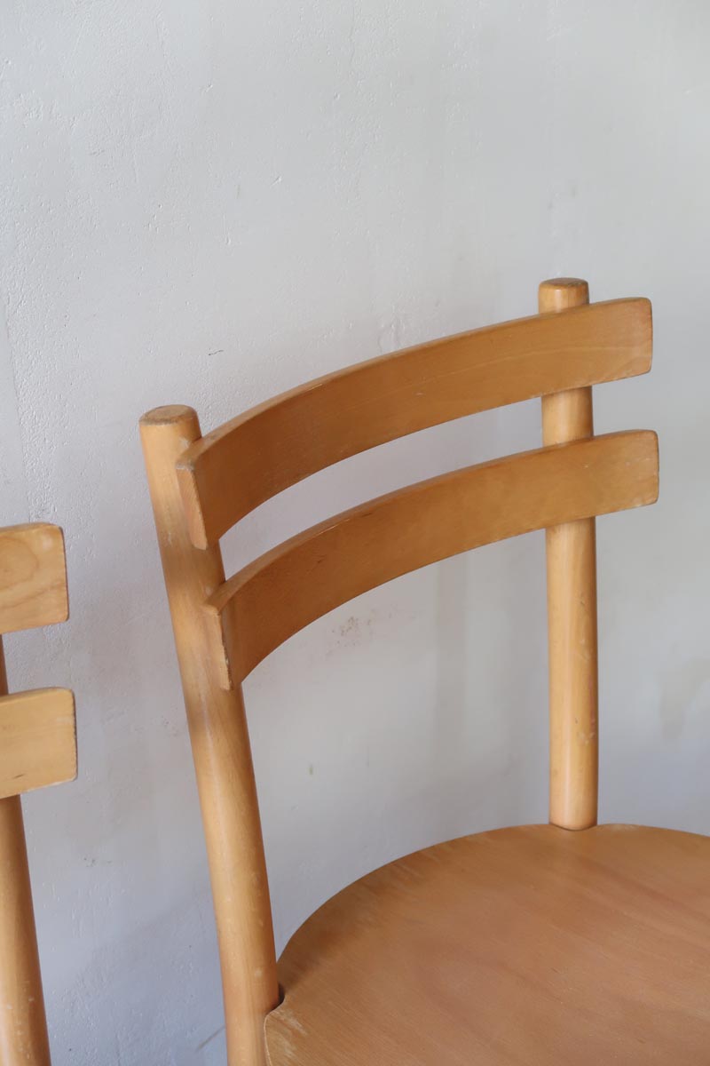 Paire de chaises vintage en hêtre massif, assise ronde et dossier à deux barreaux, style bistrot scandinave, présentées seules et en mise en situation.