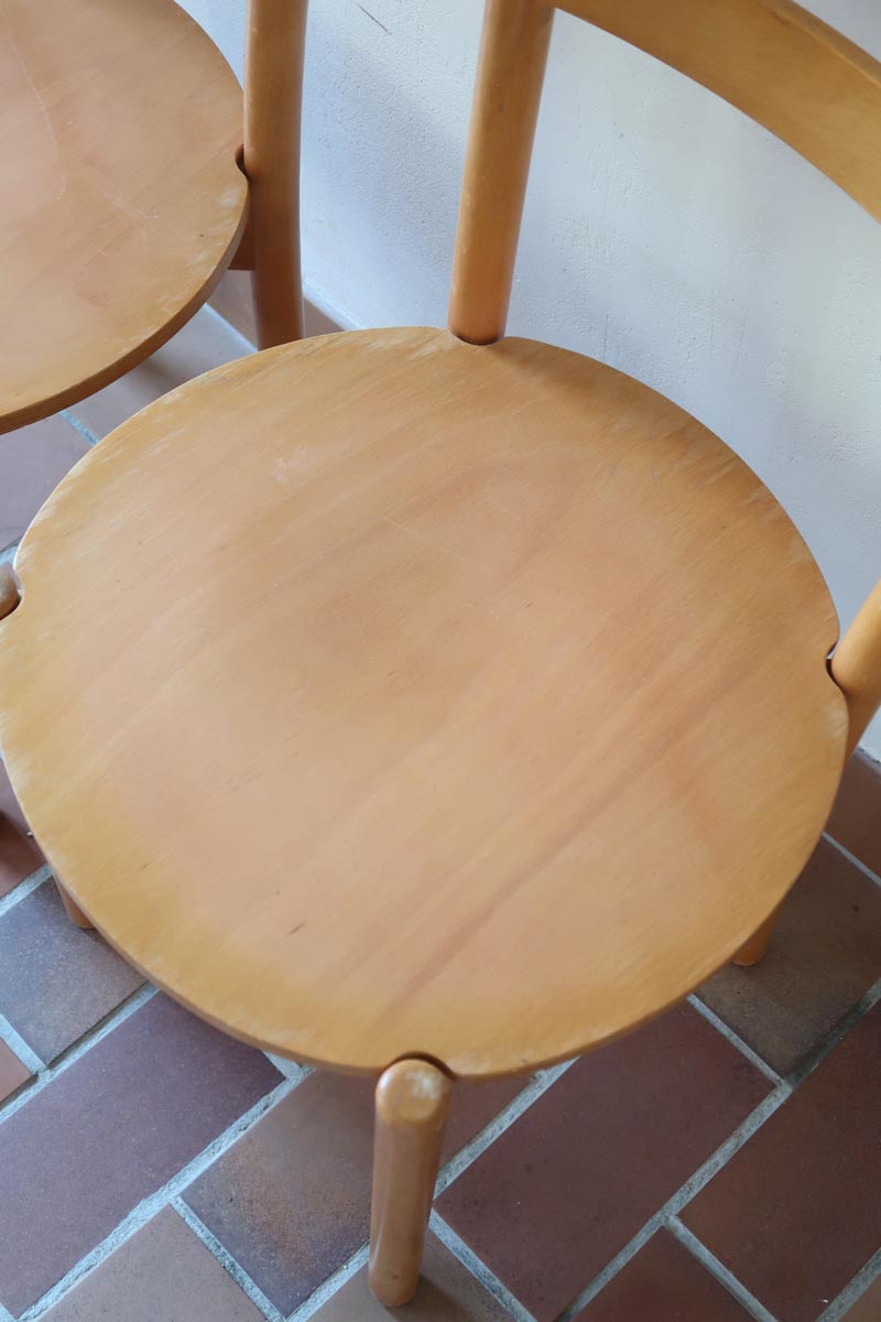 Paire de chaises vintage en hêtre massif, assise ronde et dossier à deux barreaux, style bistrot scandinave, présentées seules et en mise en situation.