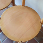 Paire de chaises vintage en hêtre massif, assise ronde et dossier à deux barreaux, style bistrot scandinave, présentées seules et en mise en situation.