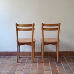 Paire de chaises vintage en hêtre massif, assise ronde et dossier à deux barreaux, style bistrot scandinave, présentées seules et en mise en situation.