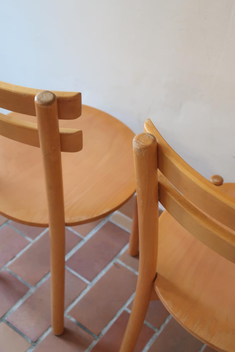 Paire de chaises vintage en hêtre massif, assise ronde et dossier à deux barreaux, style bistrot scandinave, présentées seules et en mise en situation.