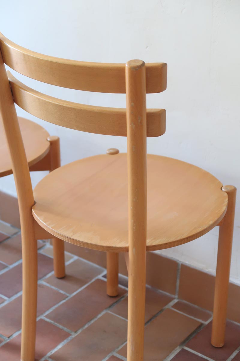 Paire de chaises vintage en hêtre massif, assise ronde et dossier à deux barreaux, style bistrot scandinave, présentées seules et en mise en situation.
