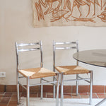 Paire de chaises modernistes des années 70 avec structure chromée et assise en paille tressée.