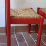Paire de chaises italiennes vintage années 70, hêtre laqué rouge, assises paille, modèle dans l'esprit Carimate de Vico Magistretti