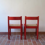 Paire de chaises italiennes vintage années 70, hêtre laqué rouge, assises paille, modèle dans l'esprit Carimate de Vico Magistretti