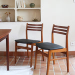 Paire de chaises scandinaves en teck avec dossier à lattes et assise en skaï noir, design danois des années 60.