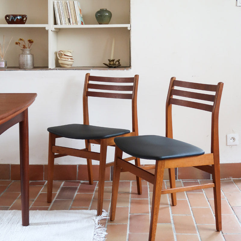 Paire de chaises scandinaves en teck avec dossier à lattes et assise en skaï noir, design danois des années 60.