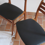 Paire de chaises scandinaves en teck avec dossier à lattes et assise en skaï noir, design danois des années 60.