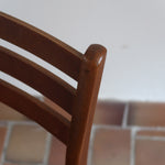 Paire de chaises scandinaves en teck avec dossier à lattes et assise en skaï noir, design danois des années 60.