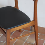 Paire de chaises scandinaves en teck avec dossier à lattes et assise en skaï noir, design danois des années 60.