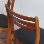 Paire de chaises scandinaves en teck avec dossier à lattes et assise en skaï noir, design danois des années 60.