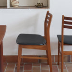 Paire de chaises scandinaves en teck avec dossier à lattes et assise en skaï noir, design danois des années 60.