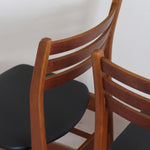 Paire de chaises scandinaves en teck avec dossier à lattes et assise en skaï noir, design danois des années 60.