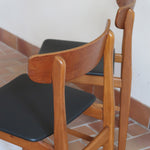 Paire de chaises scandinaves Farstrup en teck avec assise retapissée en skaï noir, design danois des années 60.