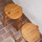 Paire de tabourets ronds vintage en pin massif, assise pleine, pieds à section carrée et entretoises chevillées, empilables, esprit Charlotte Perriand