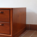 Table de chevet vintage en bois de teck, deux grands tiroirs à poignées sculptées dans la masse, socle en retrait, 70 cm de large et 45 cm de haut, fait aussi bout de canapé