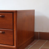 Table de chevet vintage en bois de teck, deux grands tiroirs à poignées sculptées dans la masse, socle en retrait, 70 cm de large et 45 cm de haut, fait aussi bout de canapé