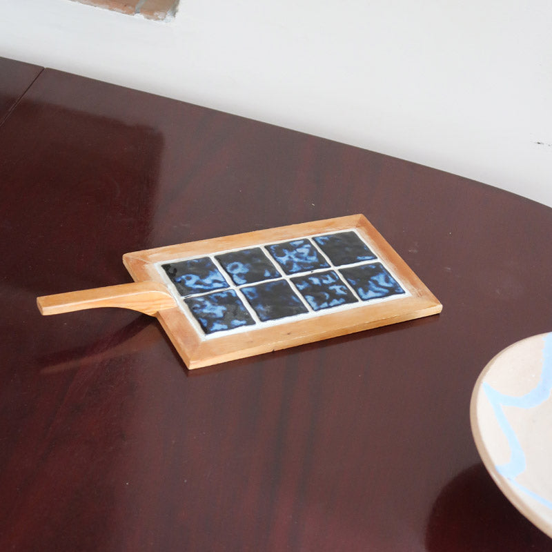 Dessous-de-plat bois clair et carreaux céramique bleu noir marbré années 60, manche spatule, artisanat français mid-century esprit Vallauris