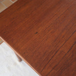 table à manger scandinave en teck massif extensible années 60 avec rallonges intégrées et piètement fuselé