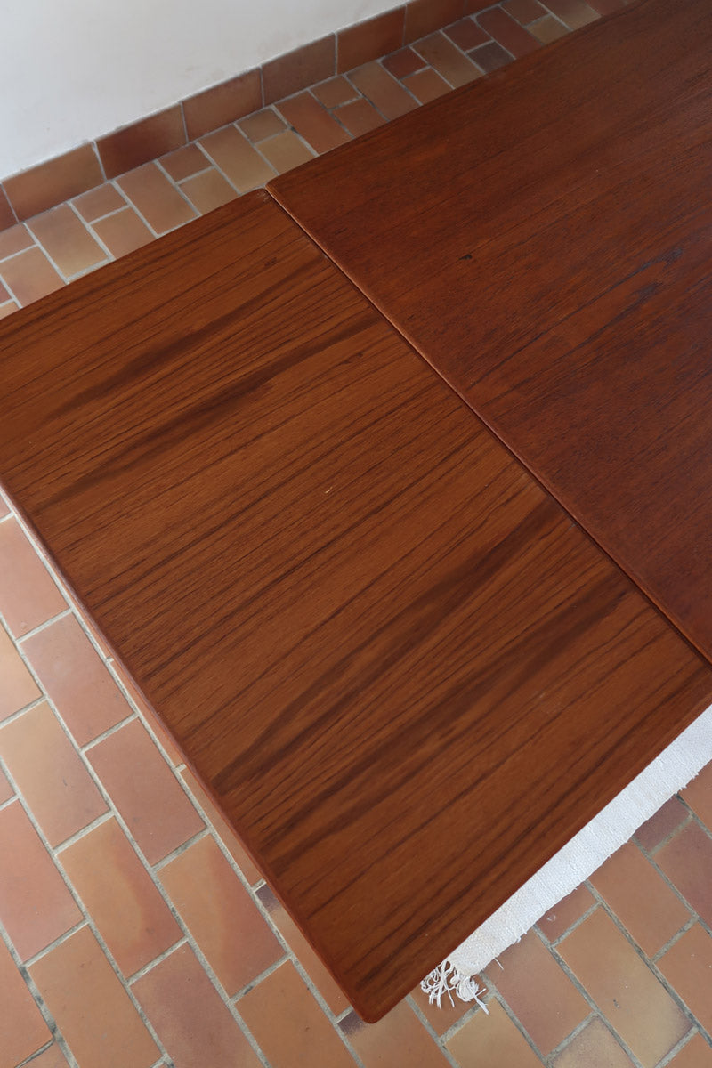 table à manger scandinave en teck massif extensible années 60 avec rallonges intégrées et piètement fuselé