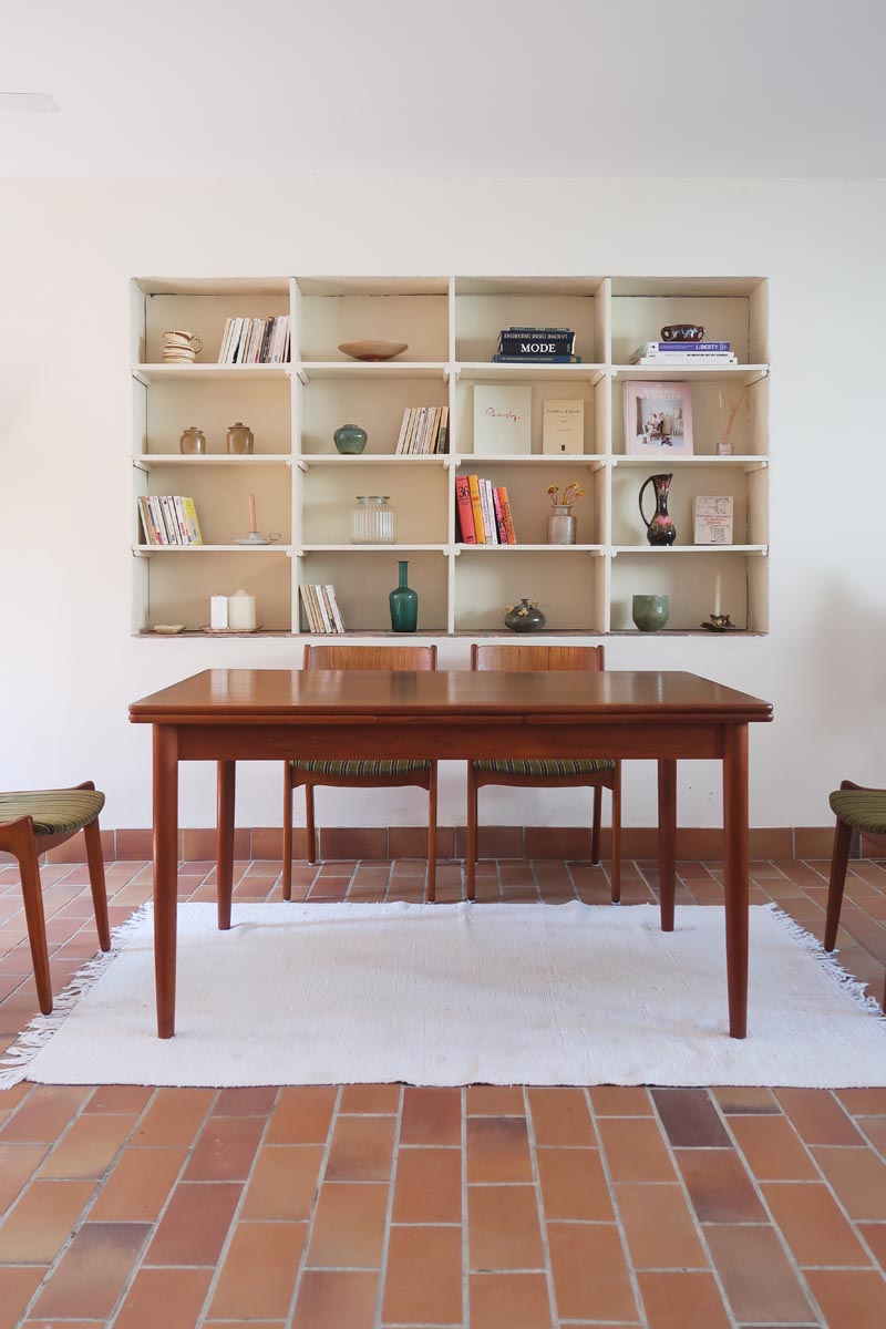 Table scandinave vintage en teck, années 60, extensible avec rallonge intégrée, pieds fuselés, quelques micro-rayures et pocs discrets visibles sur le plateau.
