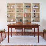 Table scandinave vintage en teck, années 60, extensible avec rallonge intégrée, pieds fuselés, quelques micro-rayures et pocs discrets visibles sur le plateau.
