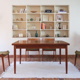 Table scandinave vintage en teck, années 60, extensible avec rallonge intégrée, pieds fuselés, quelques micro-rayures et pocs discrets visibles sur le plateau.
