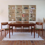 Table scandinave vintage en teck, années 60, extensible avec rallonge intégrée, pieds fuselés, quelques micro-rayures et pocs discrets visibles sur le plateau.
