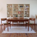 Table scandinave vintage en teck, années 60, extensible avec rallonge intégrée, pieds fuselés, quelques micro-rayures et pocs discrets visibles sur le plateau.
