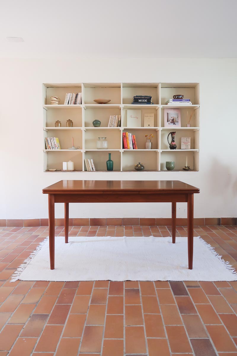 Table scandinave vintage en teck, années 60, extensible avec rallonge intégrée, pieds fuselés, quelques micro-rayures et pocs discrets visibles sur le plateau.