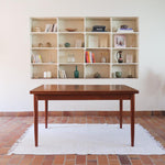 Table scandinave vintage en teck, années 60, extensible avec rallonge intégrée, pieds fuselés, quelques micro-rayures et pocs discrets visibles sur le plateau.