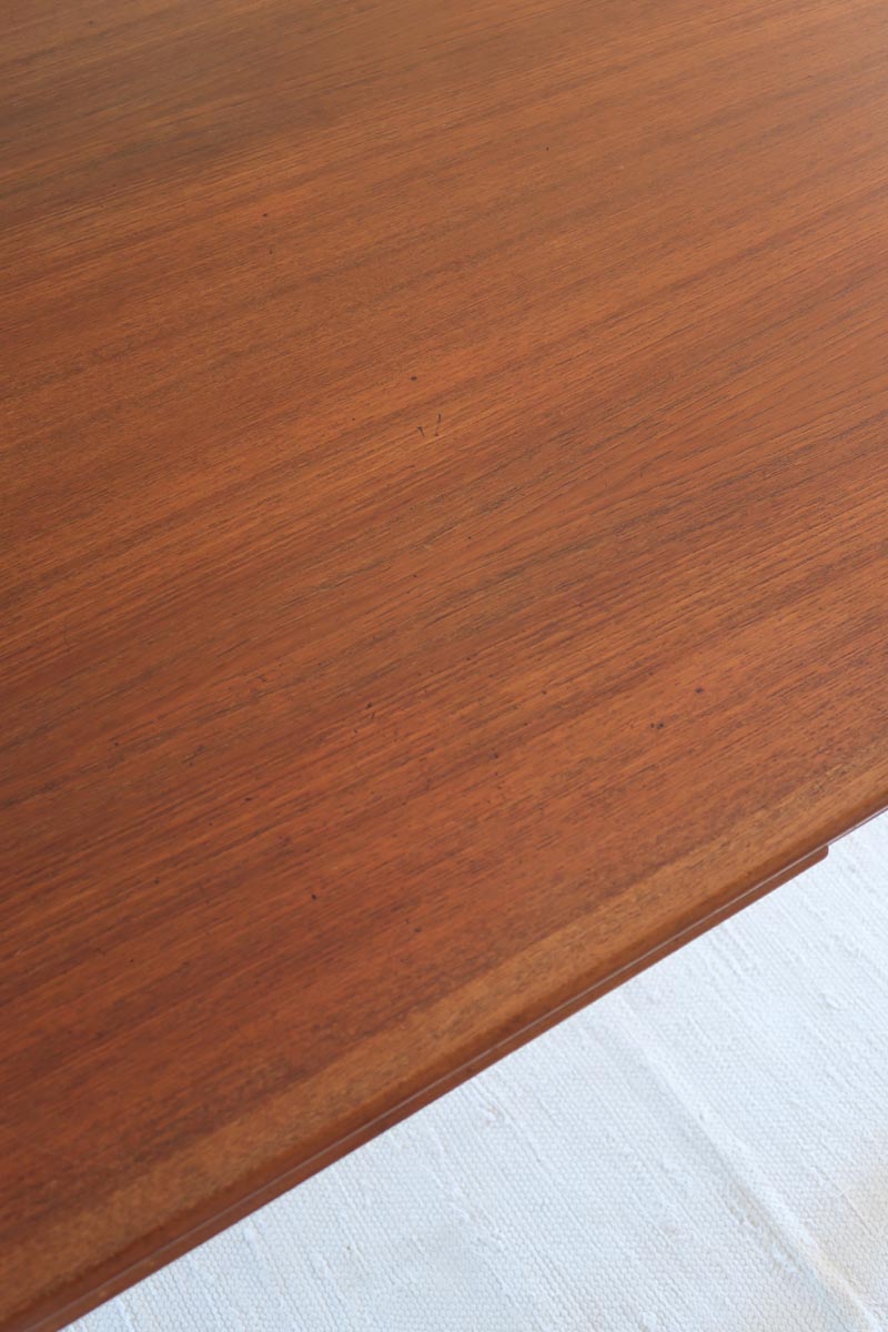 Table scandinave vintage en teck, années 60, extensible avec rallonge intégrée, pieds fuselés, quelques micro-rayures et pocs discrets visibles sur le plateau.