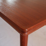 Table scandinave vintage en teck, années 60, extensible avec rallonge intégrée, pieds fuselés, quelques micro-rayures et pocs discrets visibles sur le plateau.