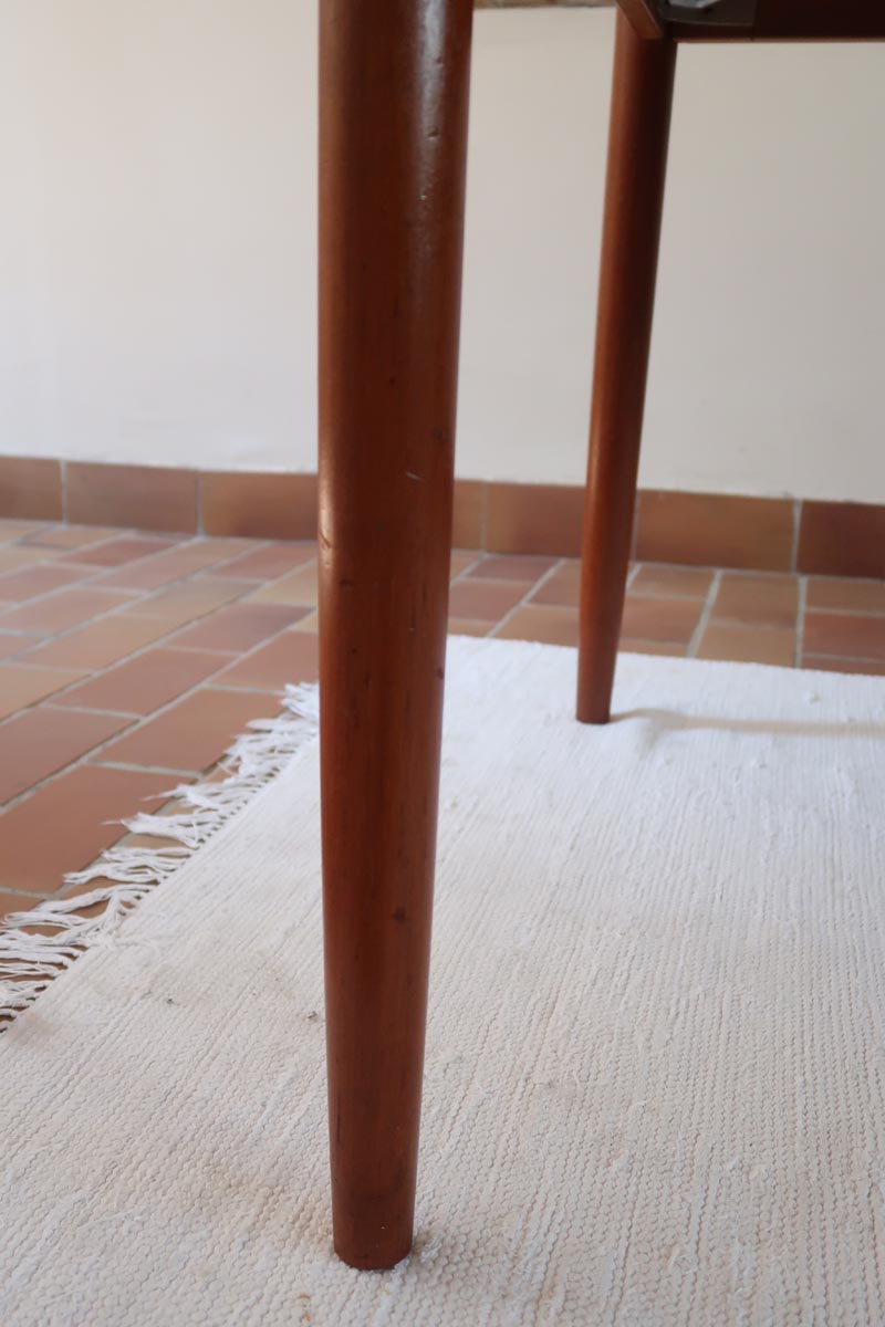 Table scandinave vintage en teck, années 60, extensible avec rallonge intégrée, pieds fuselés, quelques micro-rayures et pocs discrets visibles sur le plateau.