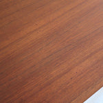 Table scandinave vintage en teck, années 60, extensible avec rallonge intégrée, pieds fuselés, quelques micro-rayures et pocs discrets visibles sur le plateau.