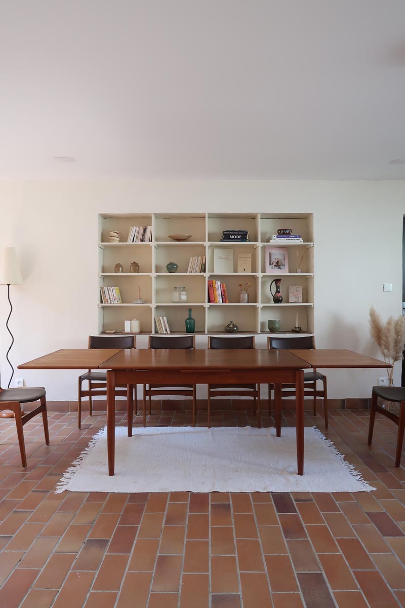 Table scandinave vintage en teck, années 60, extensible avec rallonge intégrée, pieds fuselés, quelques micro-rayures et pocs discrets visibles sur le plateau.