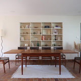 Table scandinave vintage en teck, années 60, extensible avec rallonge intégrée, pieds fuselés, quelques micro-rayures et pocs discrets visibles sur le plateau.