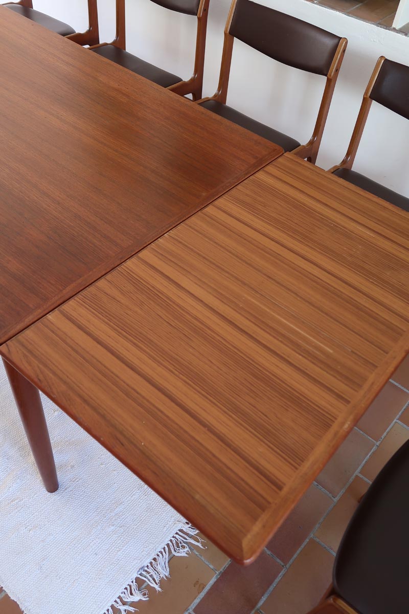 Table scandinave vintage en teck, années 60, extensible avec rallonge intégrée, pieds fuselés, quelques micro-rayures et pocs discrets visibles sur le plateau.