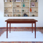 table à manger scandinave en teck massif extensible années 60 avec rallonges intégrées et piètement fuselé