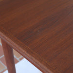 table à manger scandinave en teck massif extensible années 60 avec rallonges intégrées et piètement fuselé
