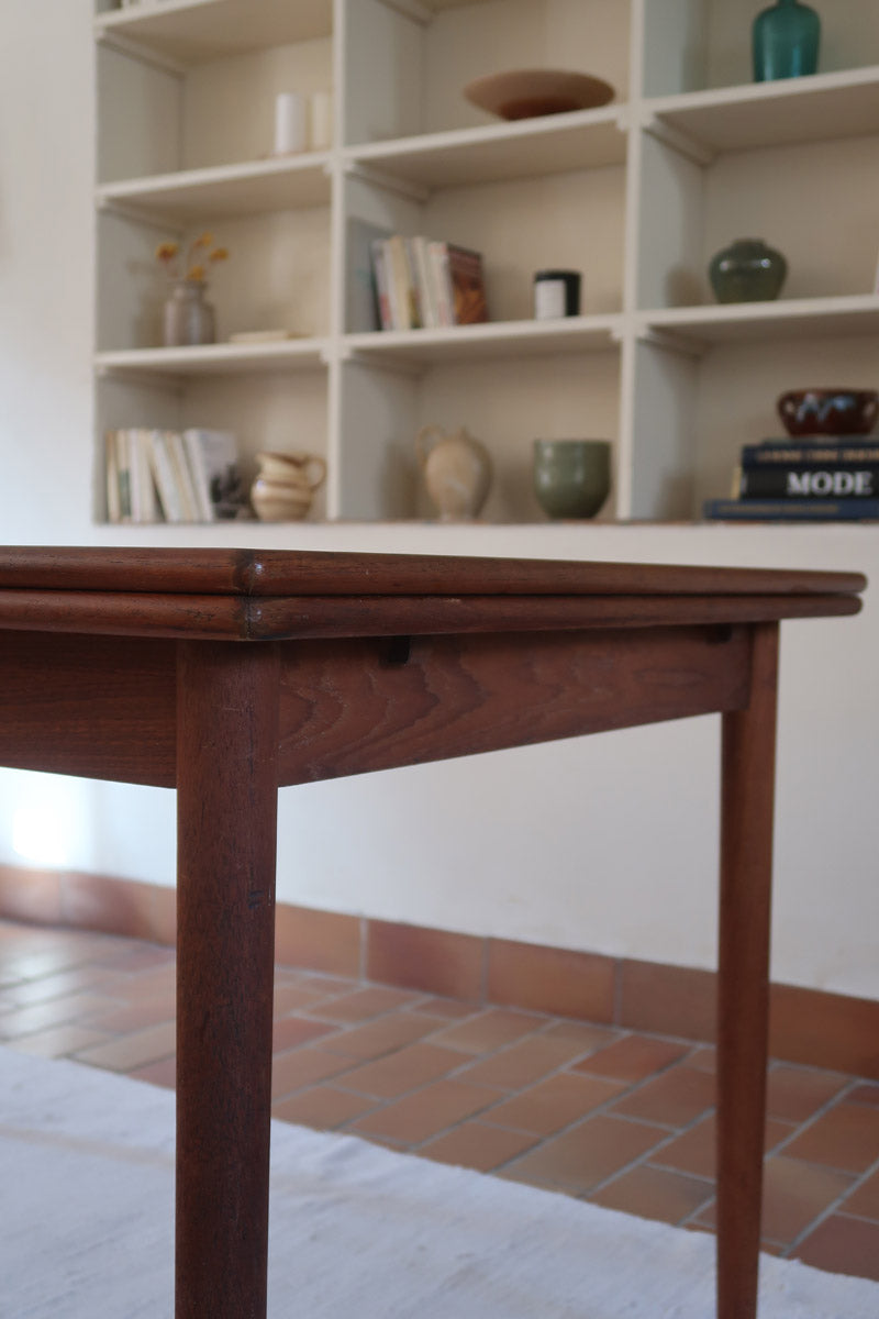 table à manger scandinave en teck massif extensible années 60 avec rallonges intégrées et piètement fuselé